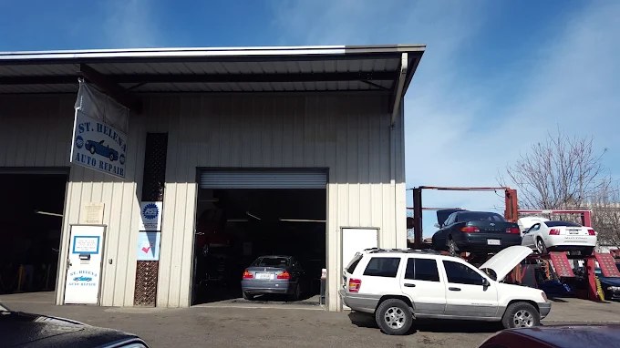 Cars in the open service bays at St. Helena Auto Repair, with a vehicle up on the lift.