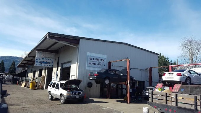 The St. Helena Auto Repair building seen from the lot, with a car raised on the lift.